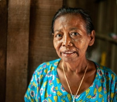 A woman in a blue shirt looking at the camera